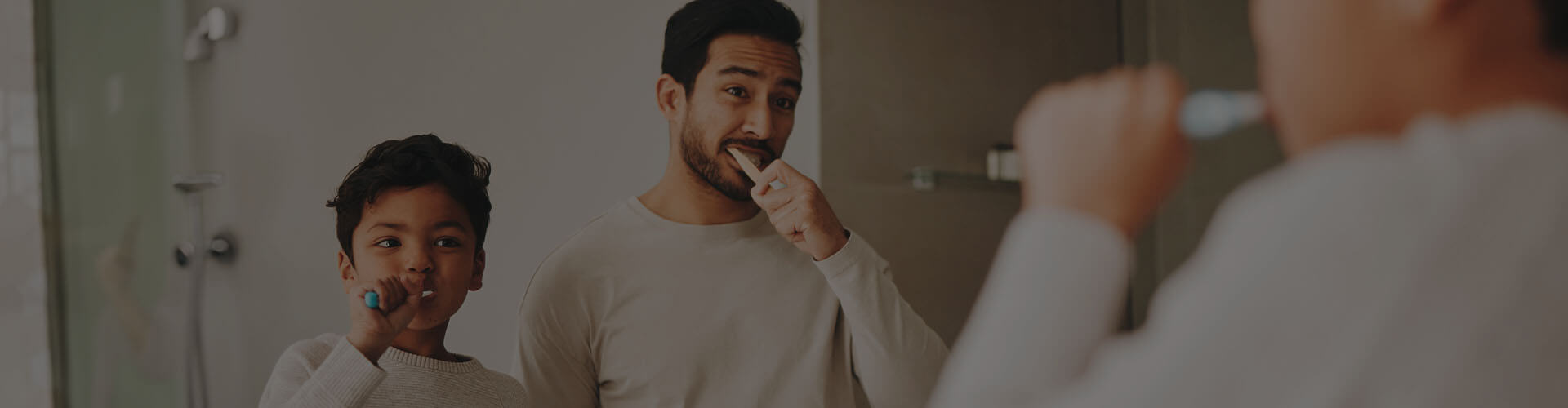 Image of father and son brushing their teeth